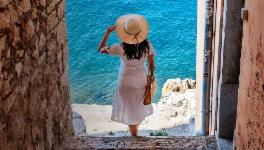 Woman standing in a passage and looking at the sea