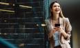 Woman reclining on a wall with mobile phone in her hands