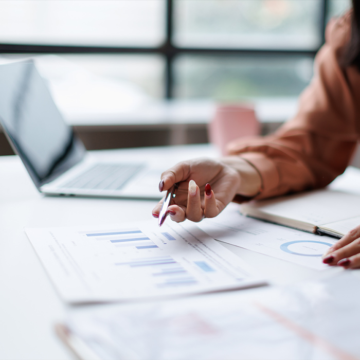 Person reviewing charts and reports on a desk
